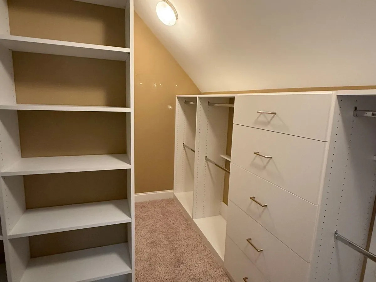 Custom white pantry with organized shelving and matte black hardware by Pi Cabinetry