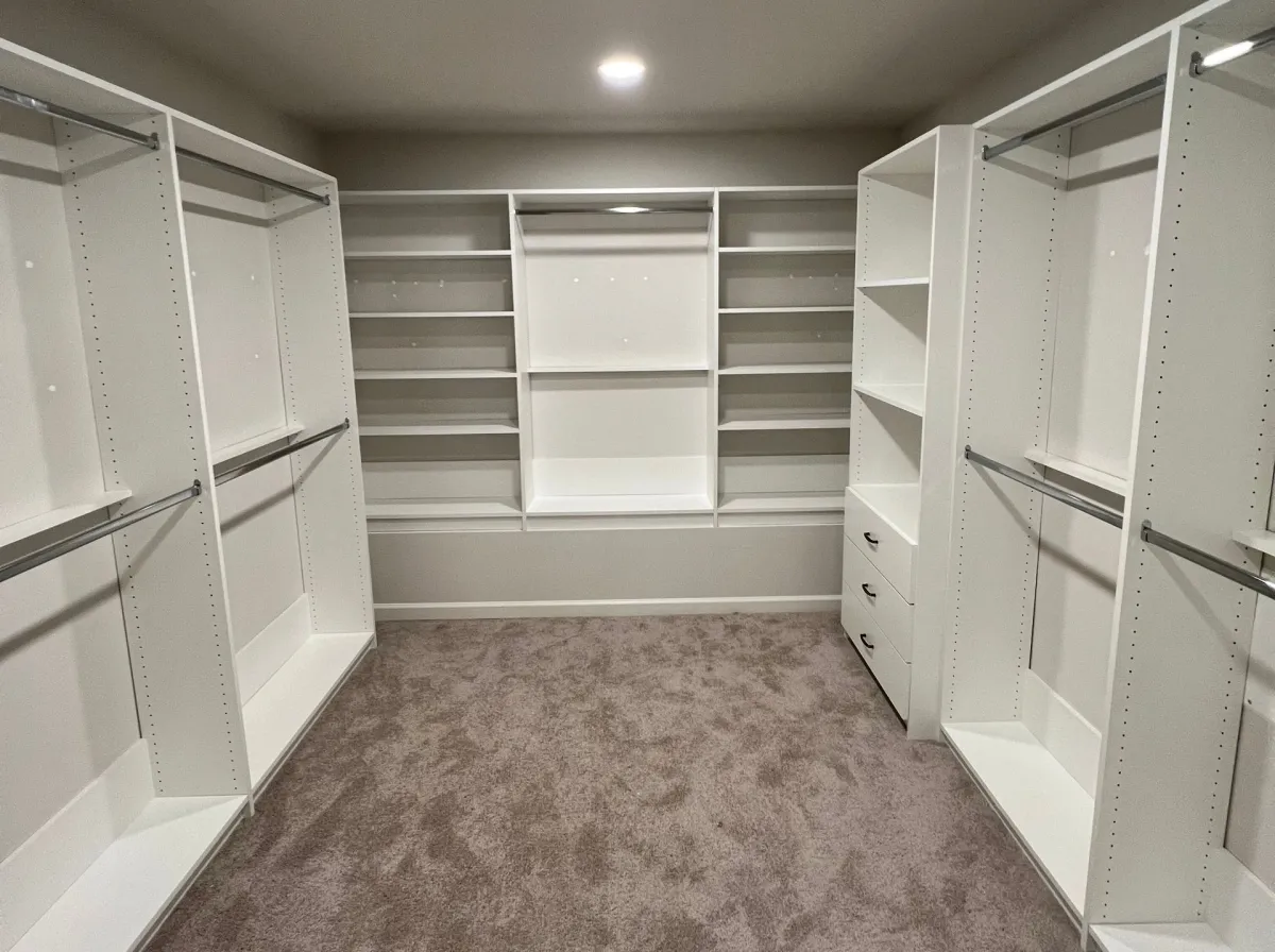 Custom white pantry with organized shelving and matte black hardware by Pi Cabinetry